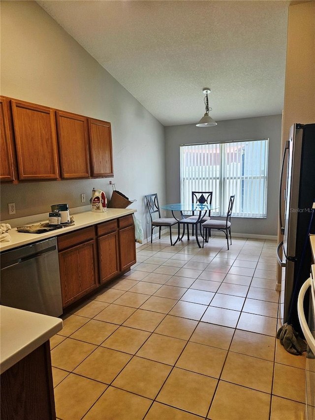 2817 Moultrie Creek Dr, Kissimmee, FL 34743 - kitchen featuring stainless steel appliances, light countertops, brown cabinets, lofted ceiling, and a textured ceiling