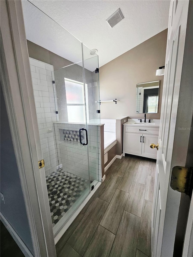 2817 Moultrie Creek Dr, Kissimmee, FL 34743 - full bathroom featuring wood finish floors, vanity, a garden tub, a shower stall, and a textured ceiling