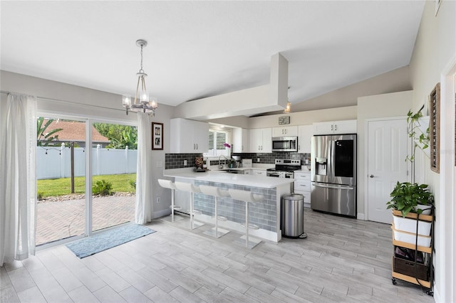 4478 Yachtmans Ct, Orlando, FL 32812 - kitchen featuring appliances with stainless steel finishes, a peninsula, light countertops, a chandelier, and a kitchen breakfast bar