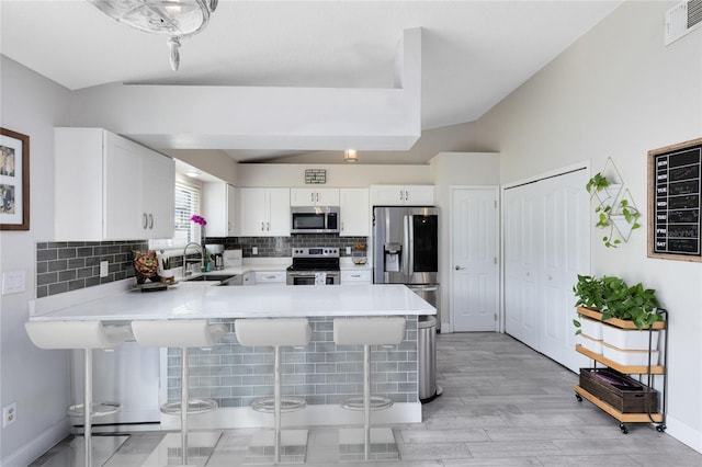 4478 Yachtmans Ct, Orlando, FL 32812 - kitchen featuring stainless steel appliances, a peninsula, a kitchen bar, and tasteful backsplash