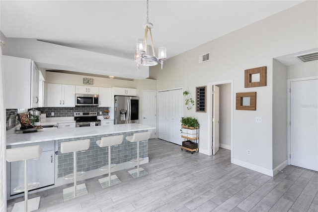 4478 Yachtmans Ct, Orlando, FL 32812 - kitchen with appliances with stainless steel finishes, light countertops, a peninsula, a breakfast bar, and a chandelier