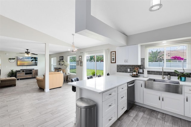 4478 Yachtmans Ct, Orlando, FL 32812 - kitchen featuring a peninsula, stainless steel dishwasher, open floor plan, light countertops, and vaulted ceiling