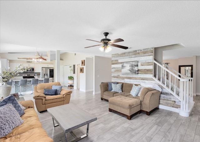 4478 Yachtmans Ct, Orlando, FL 32812 - living room featuring an accent wall, stairway, light wood-style flooring, and a ceiling fan