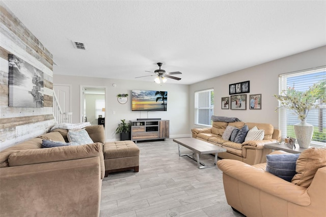 4478 Yachtmans Ct, Orlando, FL 32812 - living area featuring light wood finished floors, plenty of natural light, ceiling fan, and a textured ceiling