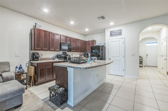 819 Lucent Sands Ct, Brandon, FL 33511 - kitchen with black appliances, light tile patterned floors, arched walkways, light countertops, and recessed lighting