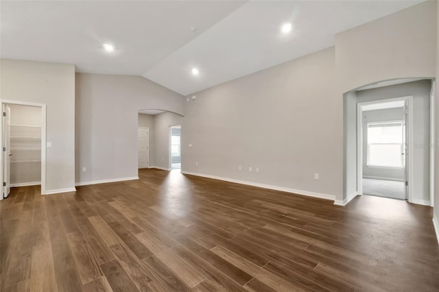 1159 Mountain Flower Ln, Davenport, FL 33837 - unfurnished living room with arched walkways, lofted ceiling, and dark wood-type flooring