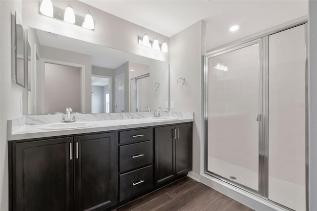 1159 Mountain Flower Ln, Davenport, FL 33837 - bathroom featuring wood finished floors, double vanity, and a stall shower