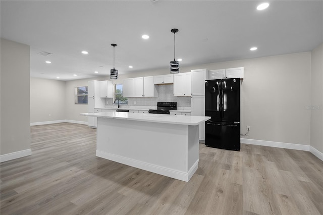 1011 W 13th St, Lakeland, FL 33805 - kitchen with black appliances, a kitchen island, light countertops, white cabinets, and recessed lighting