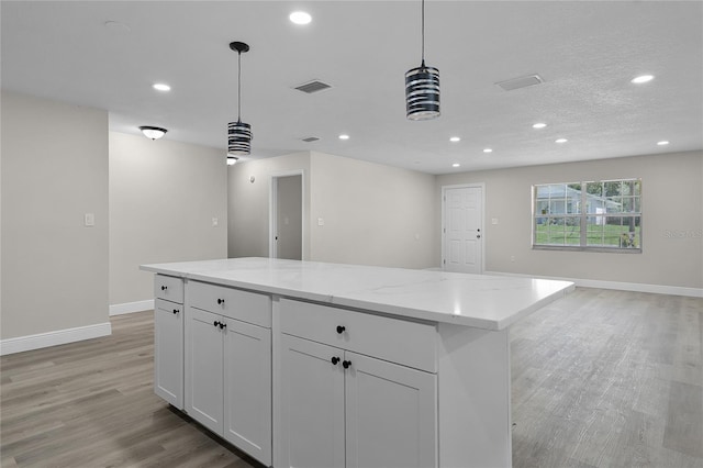 1011 W 13th St, Lakeland, FL 33805 - kitchen with recessed lighting, light wood-type flooring, hanging light fixtures, open floor plan, and white cabinetry
