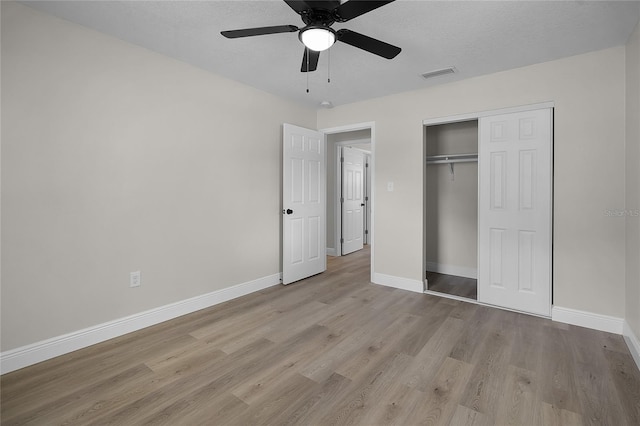 1011 W 13th St, Lakeland, FL 33805 - unfurnished bedroom featuring light wood-type flooring, a closet, a ceiling fan, and a textured ceiling