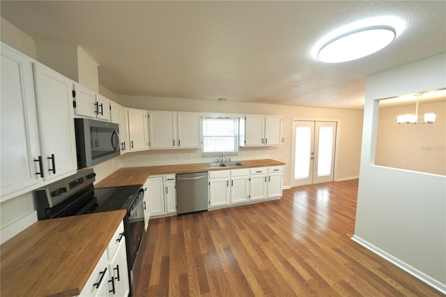 5472 E Grant St, Orlando, FL 32812 - kitchen featuring butcher block counters, stainless steel appliances, wood finished floors, and white cabinetry