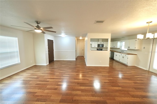 5472 E Grant St, Orlando, FL 32812 - unfurnished living room with a chandelier, a ceiling fan, and dark wood-type flooring