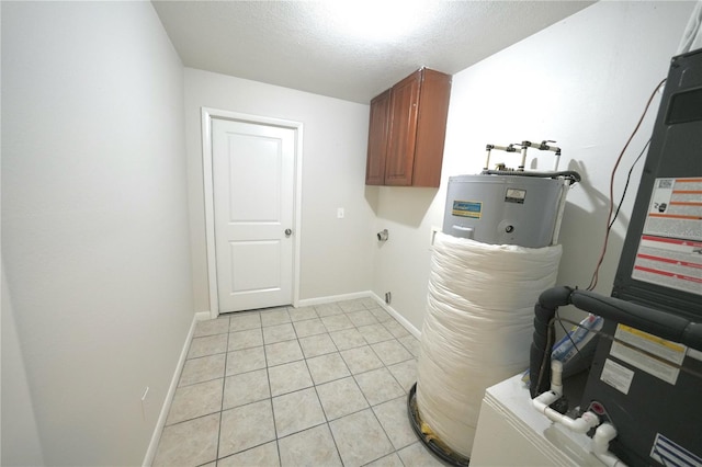 5472 E Grant St, Orlando, FL 32812 - laundry area with cabinet space, electric water heater, light tile patterned floors, and a textured ceiling