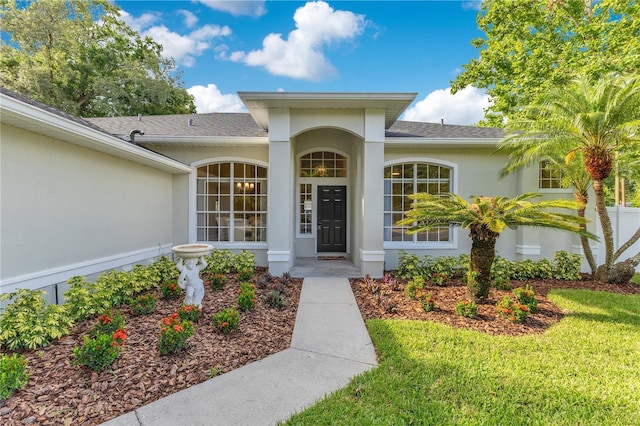 2024 Flaming Arrow Ct, Fern Park, FL 32730 - doorway to property with stucco siding, a yard, and roof with shingles