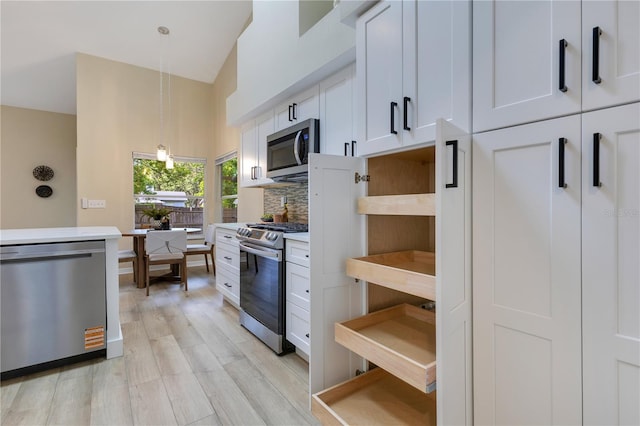 2024 Flaming Arrow Ct, Fern Park, FL 32730 - kitchen featuring stainless steel appliances, white cabinetry, light wood-style flooring, hanging light fixtures, and light countertops