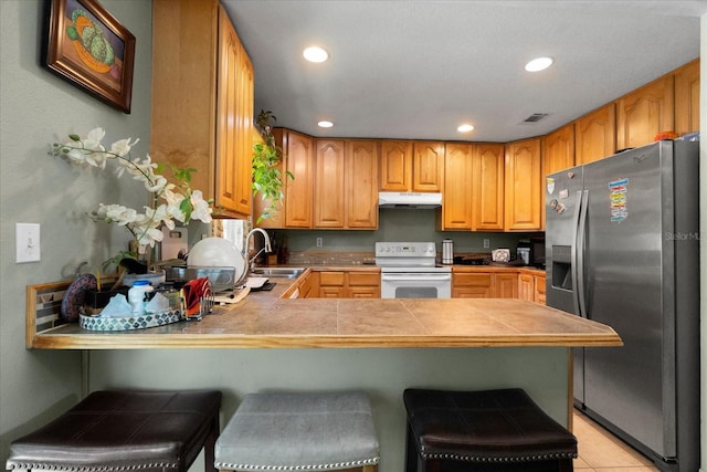 303 Mariana Way, Kissimmee, FL 34758 - kitchen featuring stainless steel fridge with ice dispenser, white range with electric stovetop, under cabinet range hood, recessed lighting, and a peninsula