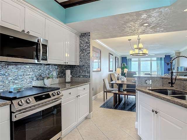 2055 S Atlantic Ave Unit 1410, Daytona Beach Shores, FL 32118 - kitchen with appliances with stainless steel finishes, crown molding, a chandelier, decorative backsplash, and light tile patterned flooring