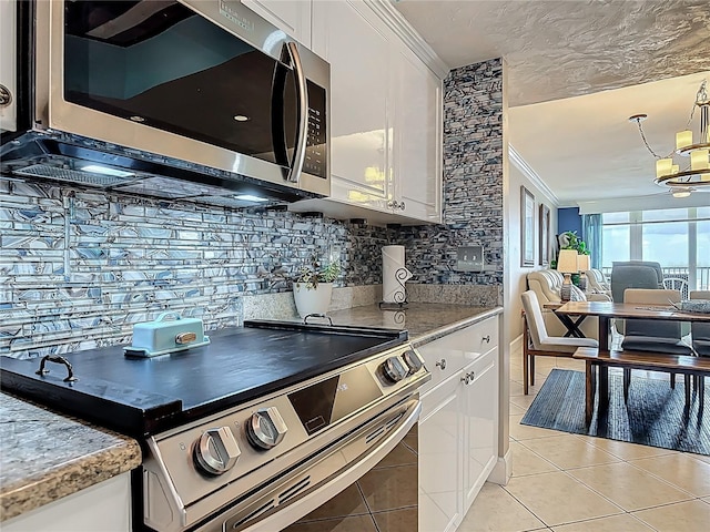 2055 S Atlantic Ave Unit 1410, Daytona Beach Shores, FL 32118 - kitchen featuring stainless steel appliances, white cabinetry, decorative backsplash, light tile patterned flooring, and crown molding