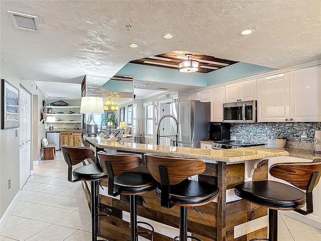 2055 S Atlantic Ave Unit 1410, Daytona Beach Shores, FL 32118 - kitchen featuring appliances with stainless steel finishes, light tile patterned flooring, a peninsula, decorative backsplash, and recessed lighting