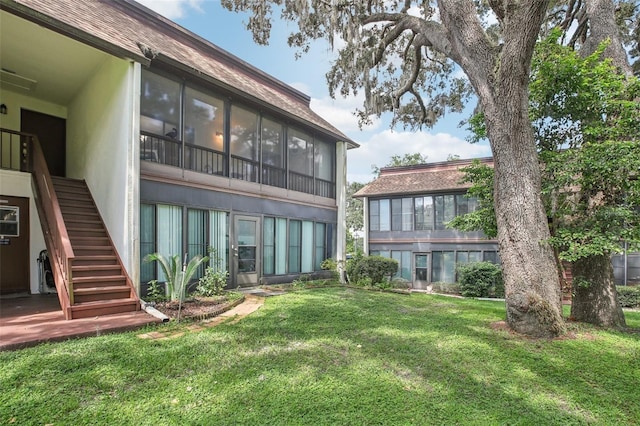 2400 Forest Dr Unit 219, Inverness, FL 34453 - back of property featuring stairway, a lawn, and stucco siding