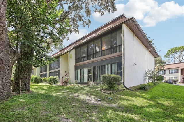 2400 Forest Dr Unit 219, Inverness, FL 34453 - back of house with stucco siding, a lawn, and a sunroom