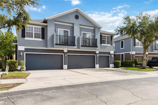 6484 S Goldenrod Rd Unit 41A, Orlando, FL 32822 - view of front of property featuring a balcony, driveway, an attached garage, and stucco siding