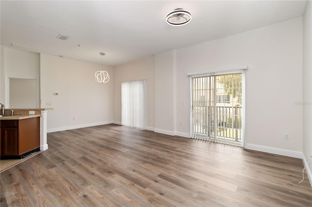 6484 S Goldenrod Rd Unit 41A, Orlando, FL 32822 - unfurnished living room featuring wood finished floors and a chandelier