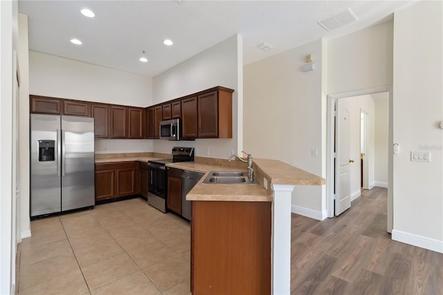 6484 S Goldenrod Rd Unit 41A, Orlando, FL 32822 - kitchen with appliances with stainless steel finishes, a peninsula, light countertops, light wood finished floors, and recessed lighting