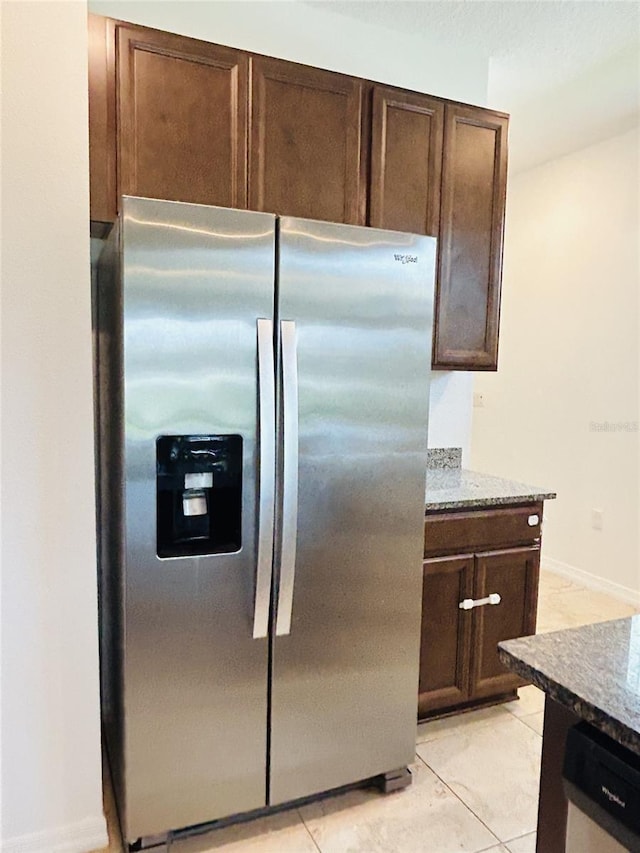 2824 Neverland Dr, New Smyrna Beach, FL 32168 - kitchen featuring stainless steel appliances, dark brown cabinets, light tile patterned floors, and stone counters
