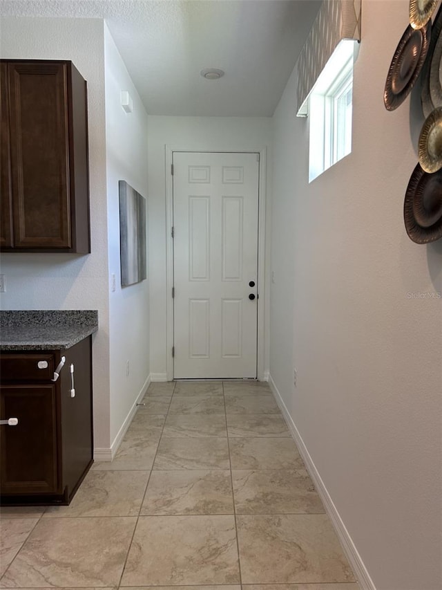 2824 Neverland Dr, New Smyrna Beach, FL 32168 - hallway featuring baseboards and light marble finish flooring