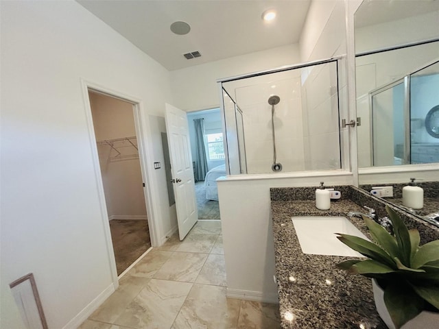 2824 Neverland Dr, New Smyrna Beach, FL 32168 - full bath featuring marble look tile flooring, a stall shower, vanity, a walk in closet, and connected bathroom