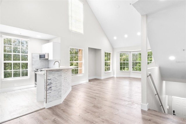 6384 Raleigh St Unit 2214, Orlando, FL 32835 - unfurnished living room with high vaulted ceiling, plenty of natural light, light wood-type flooring, and recessed lighting
