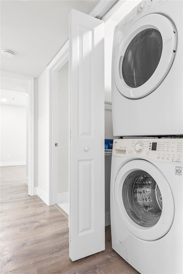 6384 Raleigh St Unit 2214, Orlando, FL 32835 - washroom featuring stacked washer / drying machine and wood finished floors