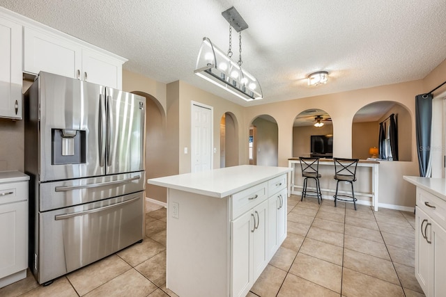 100 Monterey Oaks Dr, Sanford, FL 32771 - kitchen with stainless steel fridge, arched walkways, light tile patterned flooring, a textured ceiling, and ceiling fan