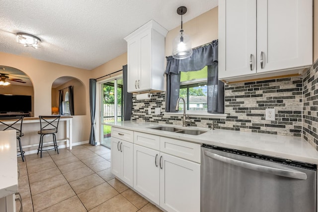100 Monterey Oaks Dr, Sanford, FL 32771 - kitchen featuring stainless steel dishwasher, light tile patterned flooring, backsplash, white cabinets, and a textured ceiling