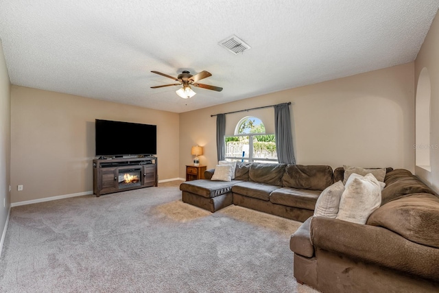 100 Monterey Oaks Dr, Sanford, FL 32771 - carpeted living area with ceiling fan, arched walkways, a glass covered fireplace, and a textured ceiling