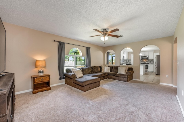 100 Monterey Oaks Dr, Sanford, FL 32771 - living area featuring a ceiling fan, arched walkways, light colored carpet, and a textured ceiling