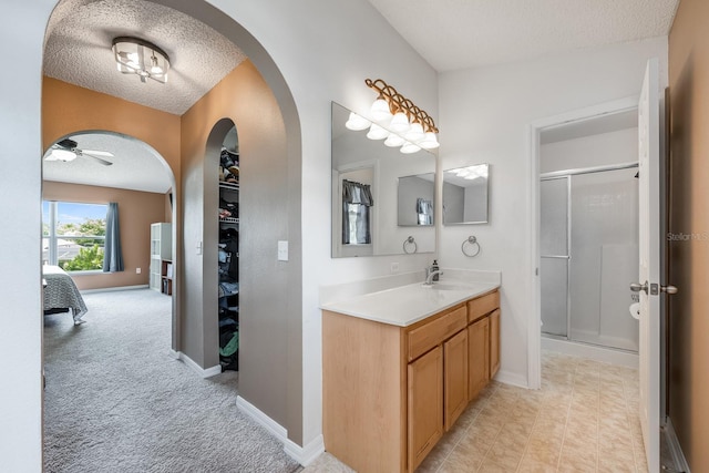100 Monterey Oaks Dr, Sanford, FL 32771 - ensuite bathroom featuring a textured ceiling, a stall shower, vanity, ceiling fan, and a spacious closet