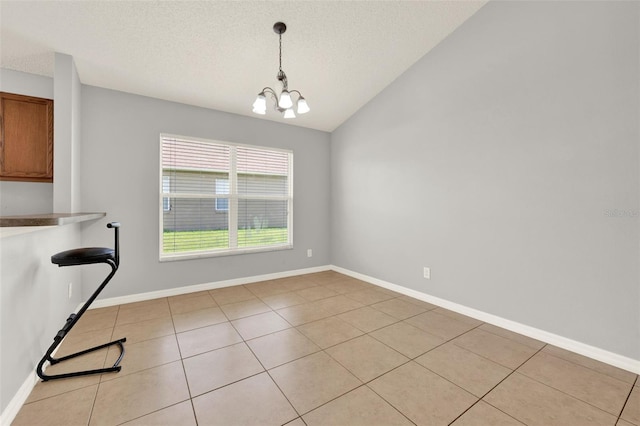 2713 Eagle Glen Cir, Kissimmee, FL 34746 - unfurnished dining area with a chandelier, a textured ceiling, light tile patterned flooring, and lofted ceiling