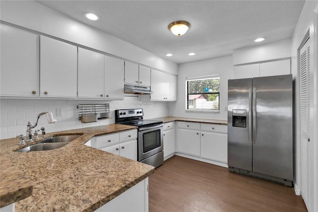 845 Valnera Ct, Kissimmee, FL 34758 - kitchen with stainless steel appliances, under cabinet range hood, backsplash, dark wood-style flooring, and white cabinetry