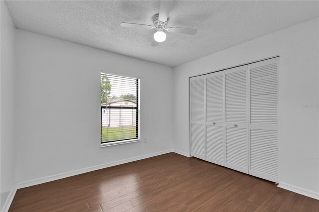 845 Valnera Ct, Kissimmee, FL 34758 - unfurnished bedroom with a textured ceiling, dark wood-type flooring, a closet, and ceiling fan