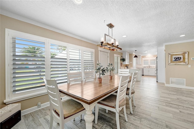 231 Ocean Blvd, Satellite Beach, FL 32937 - dining area featuring light wood-style flooring, a textured ceiling, recessed lighting, ornamental molding, and a chandelier