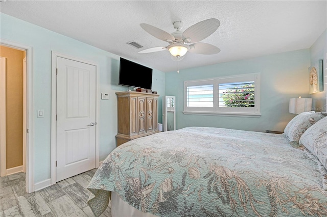 231 Ocean Blvd, Satellite Beach, FL 32937 - bedroom featuring a textured ceiling, a ceiling fan, and wood finished floors