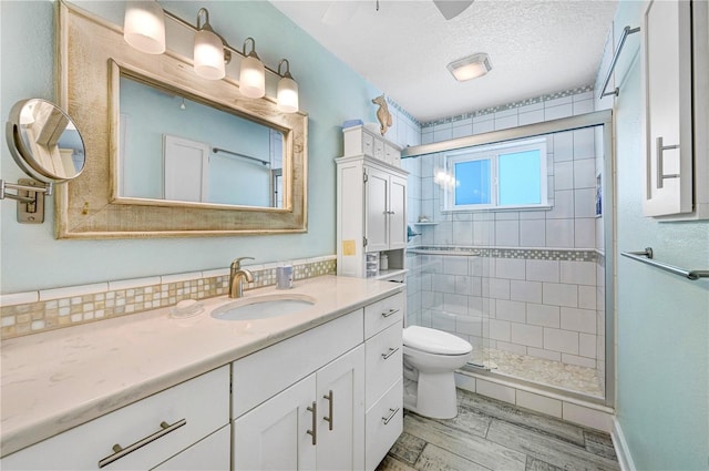231 Ocean Blvd, Satellite Beach, FL 32937 - bathroom featuring vanity, a shower stall, a textured ceiling, and wood finished floors