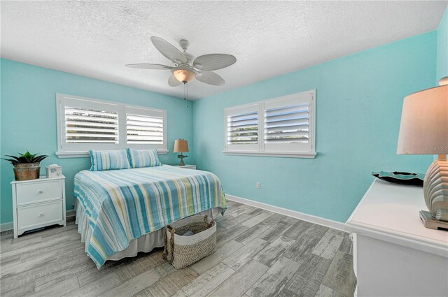 231 Ocean Blvd, Satellite Beach, FL 32937 - bedroom with light wood-style floors, a textured ceiling, and a ceiling fan