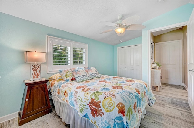 231 Ocean Blvd, Satellite Beach, FL 32937 - bedroom featuring vaulted ceiling, wood finished floors, a closet, a ceiling fan, and a textured ceiling