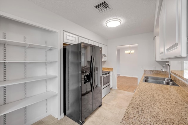 879 Tamerlane St, Deltona, FL 32725 - kitchen with black fridge, stainless steel electric range, light countertops, white cabinetry, and a textured ceiling