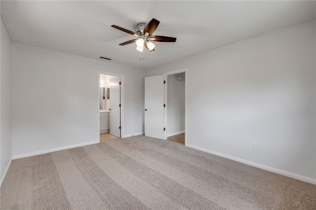 879 Tamerlane St, Deltona, FL 32725 - unfurnished bedroom featuring light colored carpet, ensuite bathroom, and a ceiling fan