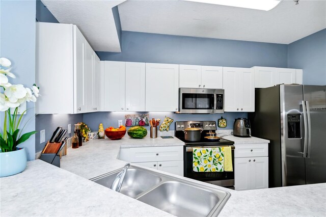 5566 Metrowest Blvd Unit 10, Orlando, FL 32811 - kitchen featuring appliances with stainless steel finishes, light countertops, and white cabinetry