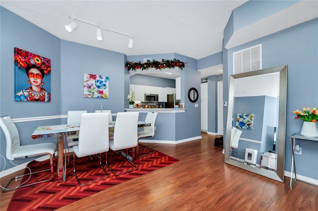 5566 Metrowest Blvd Unit 10, Orlando, FL 32811 - dining room with wood finished floors and rail lighting